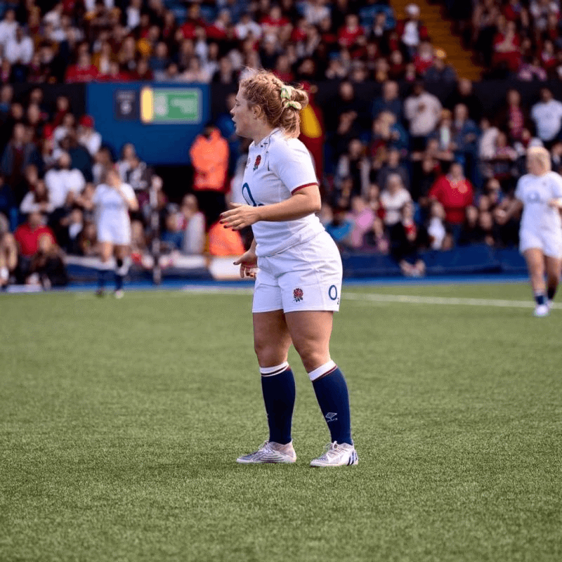 A woman on the rugby field wearing the England kit